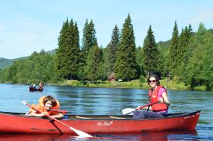 a woman and a child in a boat on a lake at Trysil Hyttegrend in Trysil
