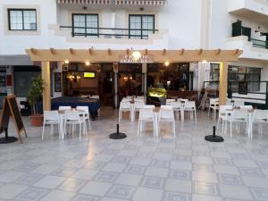 a restaurant with white chairs and tables in front of a building at Dunas do Alvor apartment 146 in Alvor