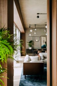 a living room with white couches and plants at Nobu Hotel Warsaw in Warsaw