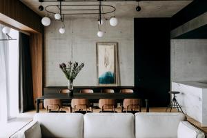 a living room with a couch and a table and chairs at Nobu Hotel Warsaw in Warsaw