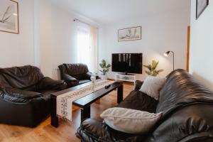 a living room with two leather chairs and a coffee table at Apartament Molo in Giżycko