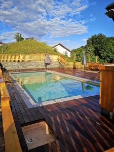 uma piscina com guarda-sóis num deque de madeira em Relax Guest Hause Marjanca em Rogaška Slatina