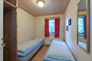two beds in a small room with a mirror at Trysil Hyttegrend in Trysil