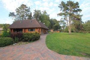 a log cabin with a brick walkway in front of a yard at The gorgeous log house, that brings out the smile! in Hara