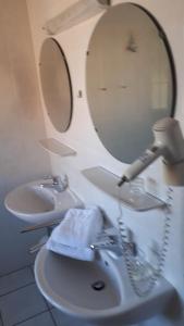a bathroom with two sinks and a blow dryer at Gasthaus Deutsches Haus garni in Wunstorf