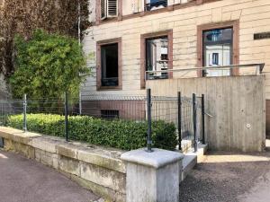 a building with a fence in front of a building at Superbe chambre chez l'habitant in Saint Die