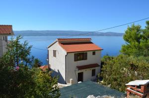 Holiday Villa in Omiš في أوميس: بيت ابيض مطل على الماء