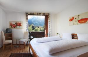 a bedroom with a large bed and a window at Hotel Auhof in Schruns