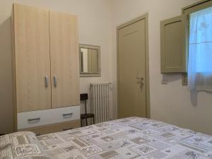 ein Schlafzimmer mit einem Bett, einem Schrank und einem Fenster in der Unterkunft I due Tesori in San Cesario di Lecce