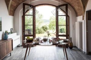 eine Küche mit einem Tisch und einem großen Fenster in der Unterkunft La Casetta in Casole dʼElsa