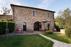 a brick building with a table and chairs in a yard at La Casetta in Casole dʼElsa