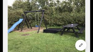 a playground with a picnic table and a swing at Bed & Bath tæt på Nationalpark Vadehavet in Ribe +13 photos