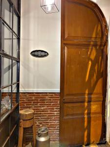 a large wooden door in a room with a stool at Can Martí in Vallgorguina