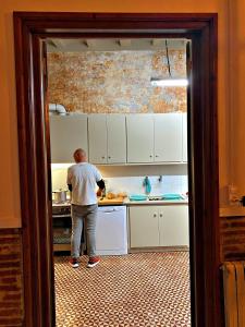 a man standing in a kitchen preparing food at Can Martí in Vallgorguina
