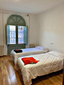 a bedroom with two beds and a window at Can Martí in Vallgorguina