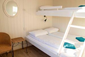 a bedroom with a bed and a chair at Puffin Hostel Vík in Vík