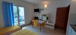 Habitación pequeña con mesa, sillas y 1 dormitorio. en Apartments Lampalo, en Okuklje