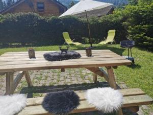 a wooden picnic table with two furry pillows on it at CHALET Indépendant Les Petits Yetis in Verchaix