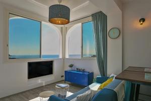 a living room with a blue couch and a large window at SunSet Cassis in Cassis