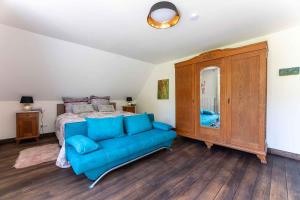 a bedroom with a blue couch in front of a bed at Altes Forsthaus - Ferienwohnung im Obergeschoss in Ormont