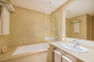 a bathroom with a tub and a sink and a mirror at Mogador Marina in Casablanca