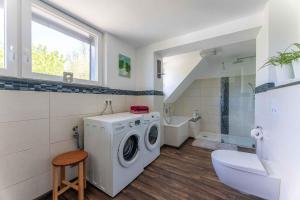a bathroom with a washing machine and a sink at Altes Forsthaus - Ferienwohnung im Obergeschoss in Ormont