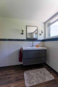 a bathroom with a sink and a mirror at Altes Forsthaus - Ferienwohnung im Obergeschoss in Ormont