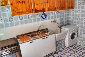 a kitchen with a sink and a washing machine at Gerani House in Cefalù