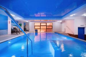 a large indoor swimming pool with blue water at Willa Arielka in Rewal