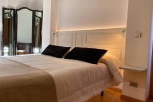 a bedroom with a large bed with two black pillows at Valdevebas Chalet con Piscina in Madrid +62 photos