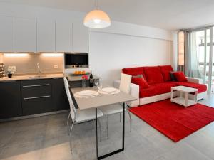 Edf CalpeMar, planta 8 - primera linea في كاليبي: مطبخ وغرفة معيشة مع أريكة حمراء