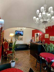 una sala de estar con paredes rojas y una lámpara de araña. en Duca di Uzeda Bed & Breakfast Luxury and Style, en Catania