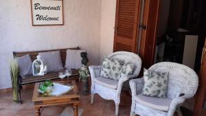 un soggiorno con 2 sedie e un tavolino da caffè di Bilocale centrale con veranda a pochi metri dalla spiaggia a Castelsardo