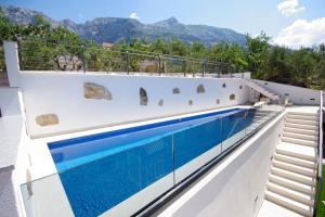 a house with a swimming pool on the roof at Apartments Makarska in Makarska