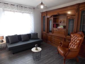 a living room with a couch and a chair at Maison de vacances "Le Longchamp" in Osenbach