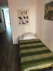 a small bed in a corner of a room at Appartement Loft Grenouillit Le Puy en Velay in Le Puy-en-Velay