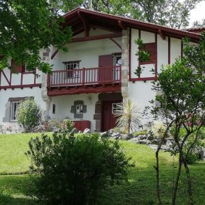 ein Haus mit einem Balkon und einem Hof in der Unterkunft VILLA XARAN ERDIAN in Espelette