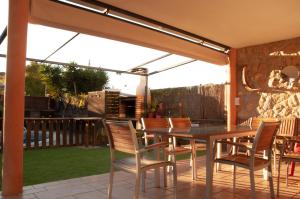 a patio with a table and chairs under awning at Alojamiento Villa Moles in Salou