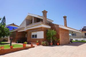 une maison en briques avec des plantes devant elle dans l'établissement Casa/Chalet Doñana, à Sanlúcar de Barrameda