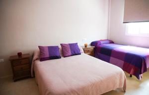 a bedroom with two beds with purple and white sheets at Casa/Chalet Doñana in Sanlúcar de Barrameda