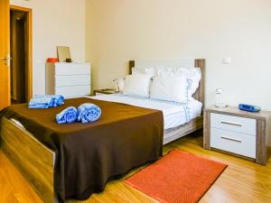 una camera da letto con un letto con asciugamani blu di Fuseta by VAGO a Fuzeta