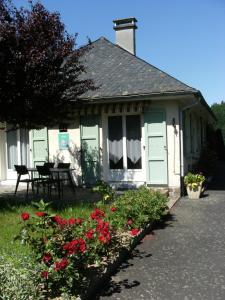 une maison avec une table et des fleurs devant elle dans l'établissement Chez Léontine, à Vic-sur-Cère