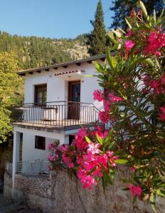 ein Haus mit rosa Blumen davor in der Unterkunft Kria springs in Livadia
