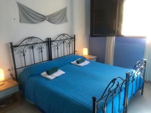 a bedroom with a blue bed with towels on it at Garden Rooms in Carloforte