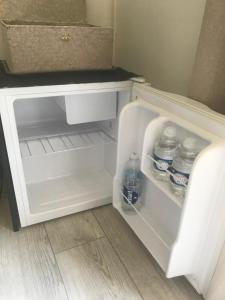 an open refrigerator with bottles of water in it at Chambre d'hôte à La maison du petit bois 4 étoiles in Ventenac-Cabardès