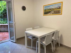comedor con mesa blanca y sillas en Appartamento Maraschino, en Levanto
