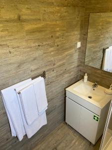 a bathroom with a sink and a mirror and towels at Silver Coast Vacation - Your Unique Inn in Lourinhã