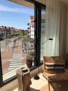 a living room with a view of a street from a window at Suite 133 hotel studio in Knokke-Heist