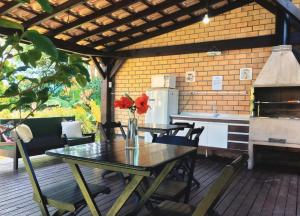 een patio met een tafel en een keuken met een fornuis bij Pousada Rosa 08 in Praia do Rosa