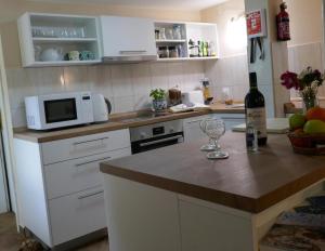 a kitchen with a counter with a microwave and a wine glass at EcoHouse Risan Studio in Risan